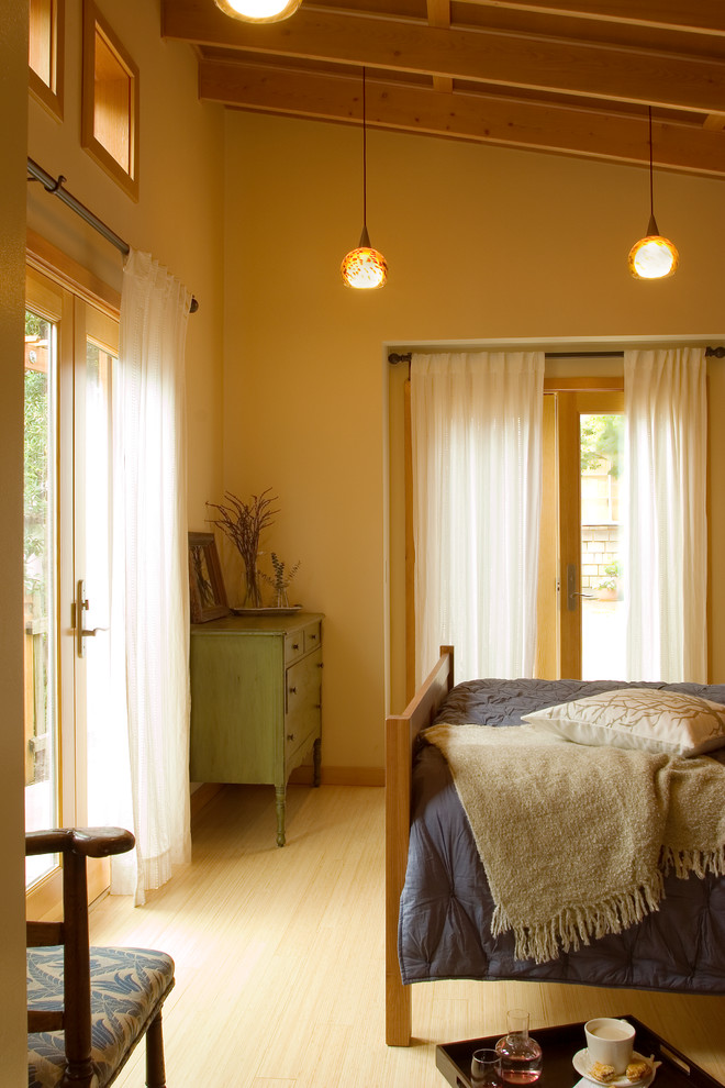 This is an example of a mid-sized eclectic master bedroom in San Francisco with beige walls and bamboo floors.