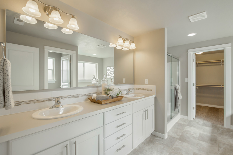 Photo of a large arts and crafts master bathroom in Other with white cabinets, ceramic tile, vinyl floors, laminate benchtops, grey floor and a sliding shower screen.