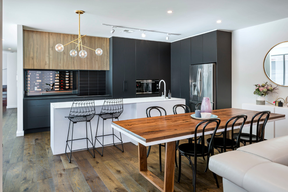 This is an example of a contemporary galley eat-in kitchen in Adelaide with black cabinets, black splashback, with island, flat-panel cabinets, subway tile splashback and medium hardwood floors.