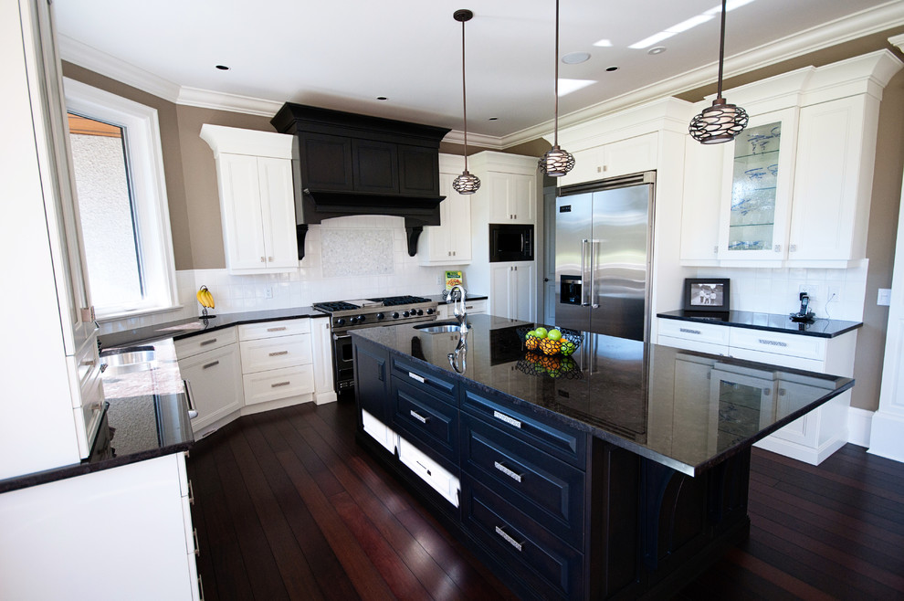 Photo of a large transitional u-shaped kitchen in Vancouver with an undermount sink, shaker cabinets, white cabinets, quartzite benchtops, white splashback, ceramic splashback, stainless steel appliances, dark hardwood floors and with island.