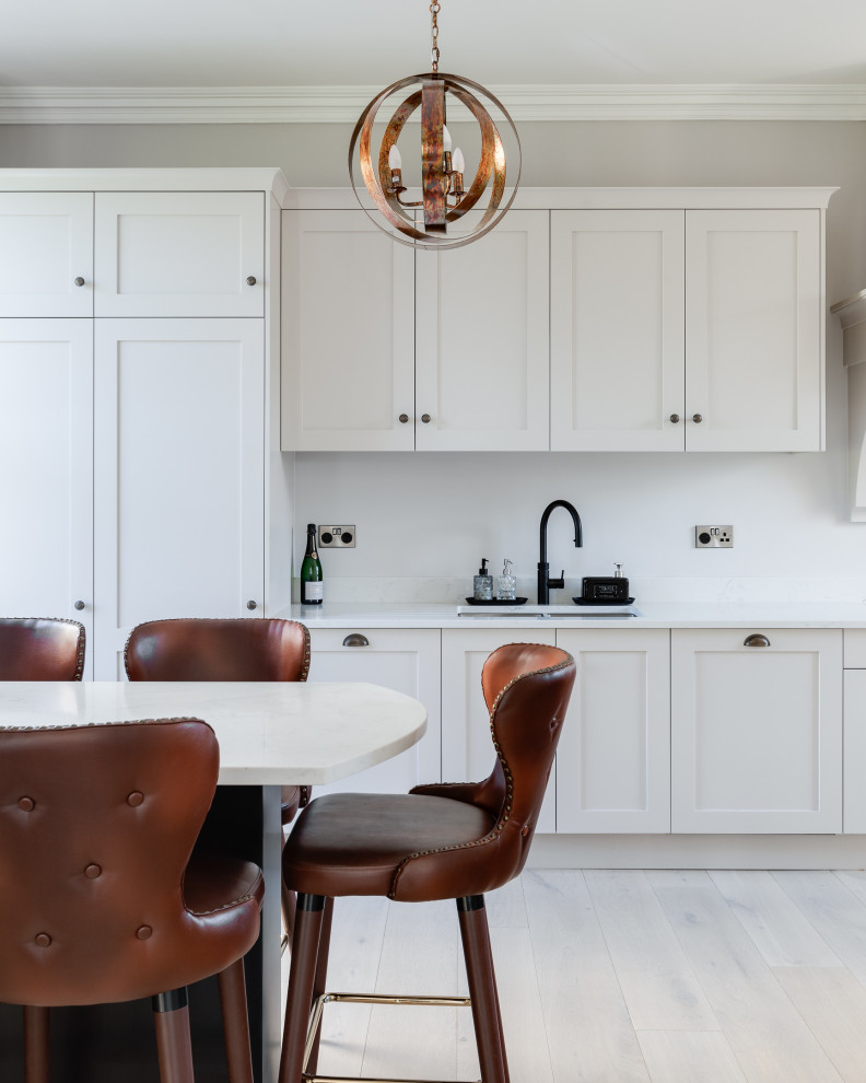 Example of a large classic single-wall eat-in kitchen design in Hertfordshire with shaker cabinets, gray cabinets, quartzite countertops, a peninsula and white countertops
