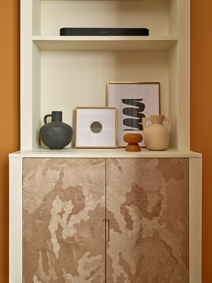 Идея дизайна: большая гостиная комната в стиле неоклассика (современная классика) с оранжевыми стенами, печью-буржуйкой, скрытым телевизором, коричневым полом и акцентной стеной
