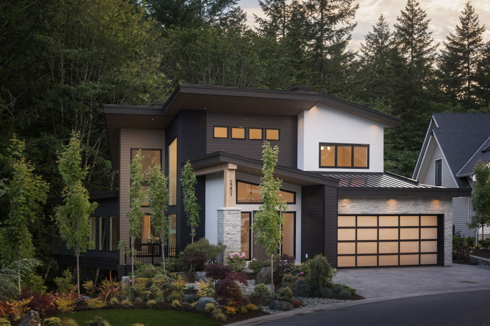 Inspiration for a mid-sized contemporary three-storey beige house exterior in Vancouver with concrete fiberboard siding, a butterfly roof, a metal roof, a black roof and clapboard siding.