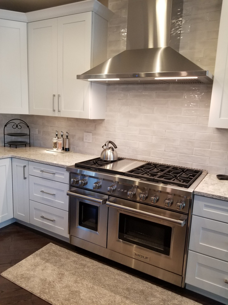 Kitchen - transitional l-shaped dark wood floor and brown floor kitchen idea in Chicago with shaker cabinets, white cabinets, quartz countertops and an island