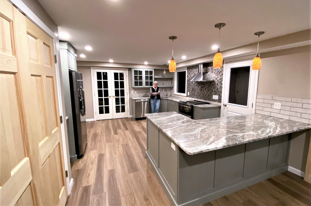 Inspiration for a mid-sized transitional u-shaped vinyl floor and brown floor eat-in kitchen remodel in Boston with an undermount sink, recessed-panel cabinets, gray cabinets, granite countertops, beige backsplash, ceramic backsplash, stainless steel appliances, a peninsula and multicolored countertops