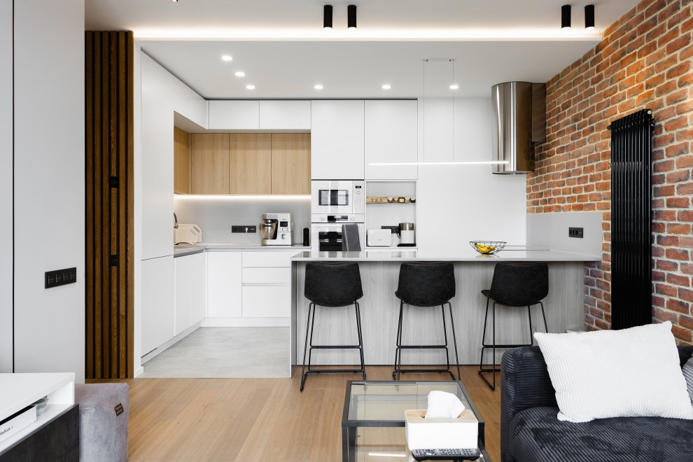 Design ideas for a mid-sized contemporary l-shaped open plan kitchen in Moscow with an undermount sink, flat-panel cabinets, white cabinets, solid surface benchtops, grey splashback, white appliances, porcelain floors, a peninsula, grey floor, grey benchtop and recessed.