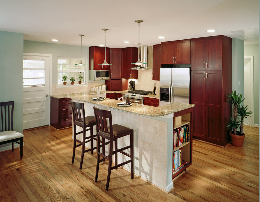 Design ideas for a small traditional l-shaped eat-in kitchen in Dallas with an undermount sink, shaker cabinets, dark wood cabinets, granite benchtops, beige splashback, ceramic splashback, stainless steel appliances, medium hardwood floors, with island and beige floor.