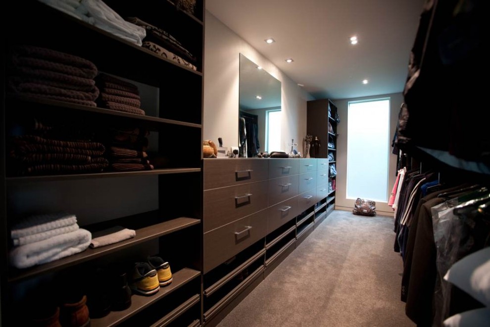Design ideas for a large contemporary gender-neutral walk-in wardrobe in Auckland with flat-panel cabinets, light wood cabinets and carpet.