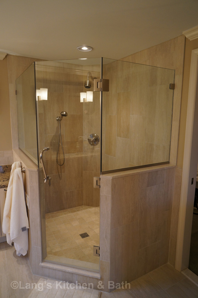 Photo of a large traditional bathroom in Philadelphia with an undermount sink, furniture-like cabinets, dark wood cabinets, engineered quartz benchtops, a drop-in tub, a corner shower, a one-piece toilet, beige tile, porcelain tile, beige walls and porcelain floors.