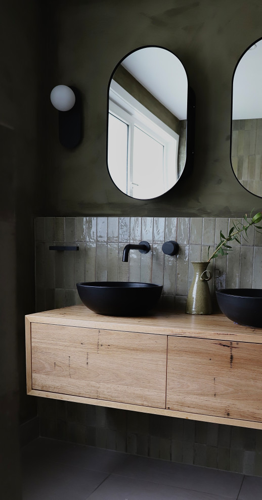 Esempio di una stanza da bagno con ante in legno scuro, piastrelle verdi, pareti verdi, top in legno, due lavabi e mobile bagno sospeso