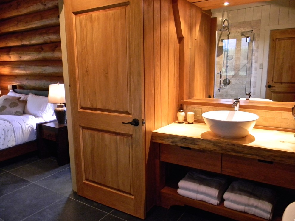 Design ideas for a mid-sized country 3/4 bathroom in Montreal with a vessel sink, flat-panel cabinets, medium wood cabinets, wood benchtops, a one-piece toilet, beige tile, stone tile, brown walls and slate floors.