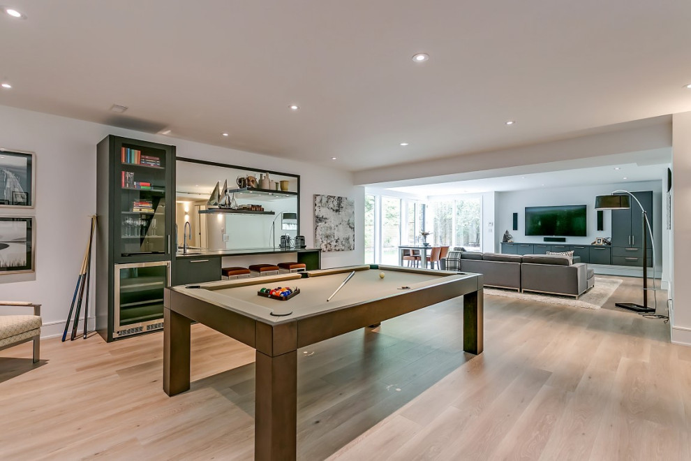 Basement - large transitional walk-out light wood floor basement idea in Toronto with white walls