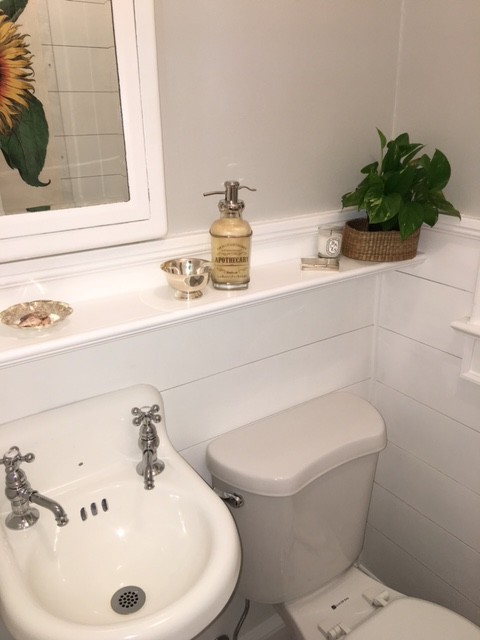 Photo of a small transitional powder room in New York with glass-front cabinets, white cabinets, a one-piece toilet, white tile, marble, grey walls, marble floors, a wall-mount sink, marble benchtops and grey floor.