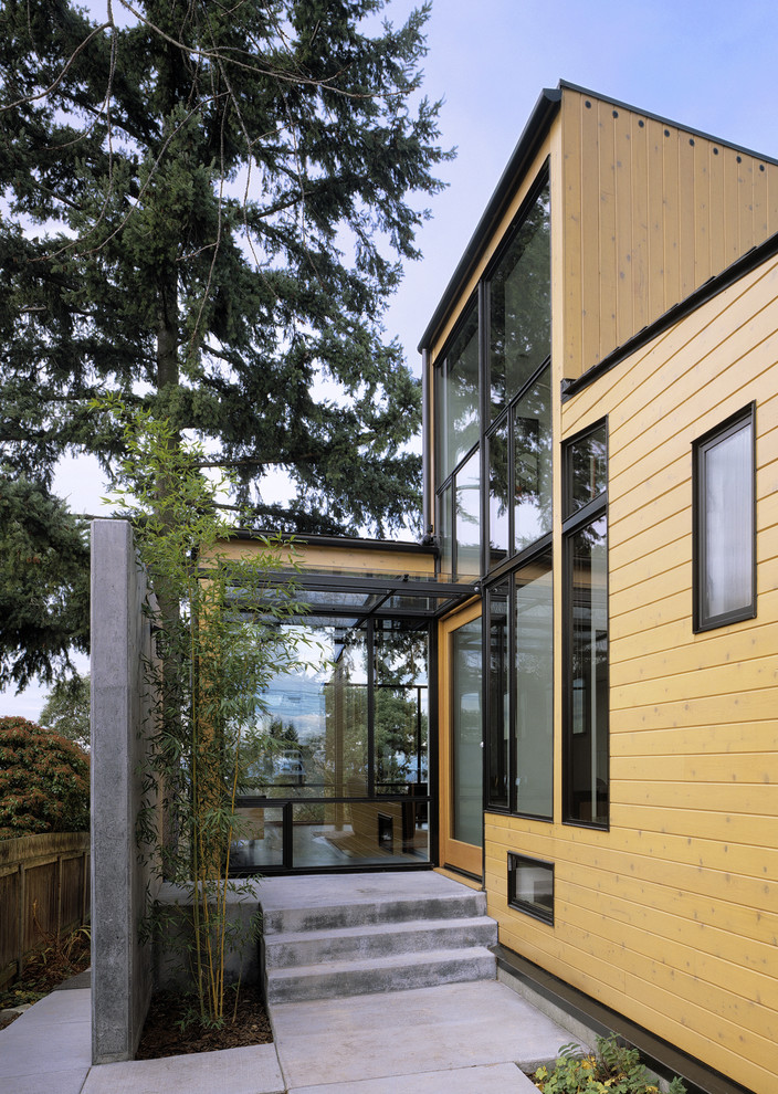This is an example of a modern entryway in Seattle with a single front door and a glass front door.