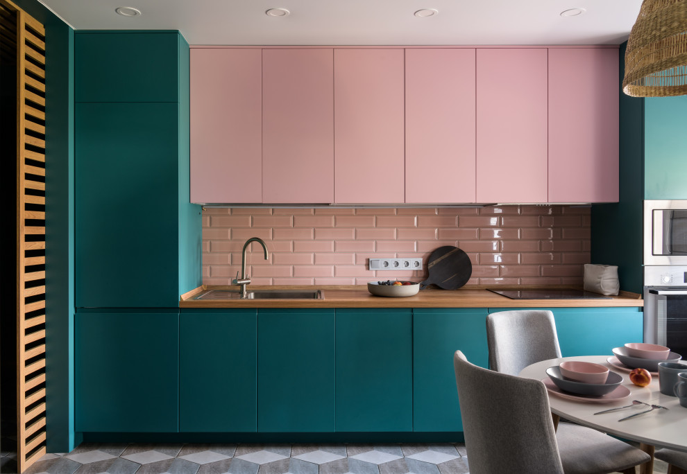 This is an example of a mid-sized contemporary single-wall eat-in kitchen in Novosibirsk with a drop-in sink, flat-panel cabinets, pink cabinets, laminate benchtops, pink splashback, subway tile splashback, stainless steel appliances, ceramic floors, no island and brown benchtop.