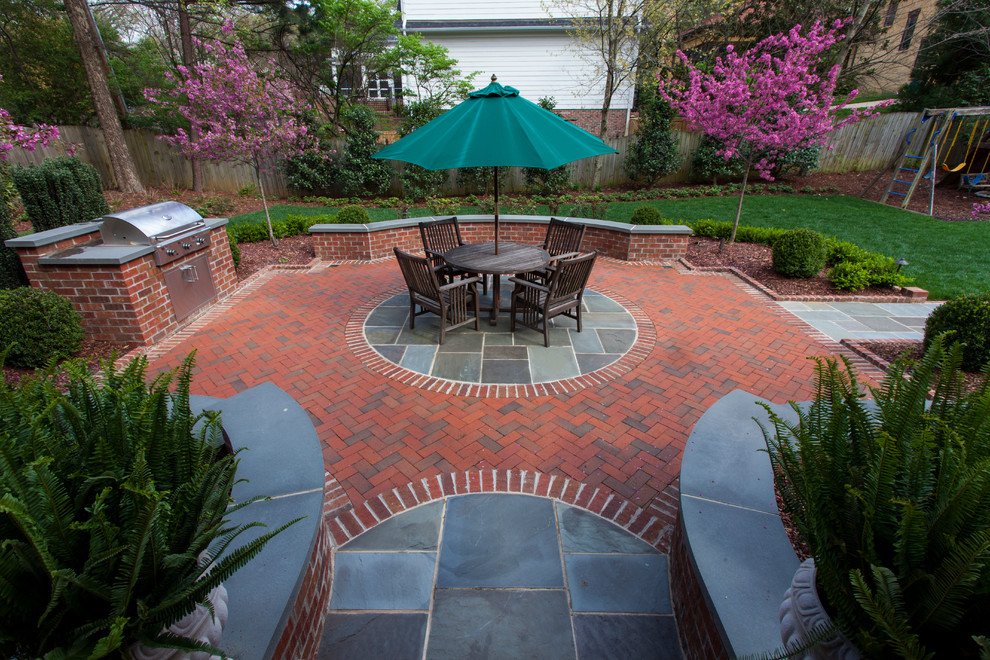 This is an example of a mid-sized traditional backyard garden in Charlotte with brick pavers.