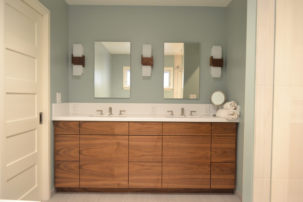 Large modern master bathroom in San Francisco with flat-panel cabinets, medium wood cabinets, a freestanding tub, a double shower, white tile, porcelain tile, green walls, porcelain floors, an integrated sink, solid surface benchtops, multi-coloured floor, a hinged shower door and white benchtops.