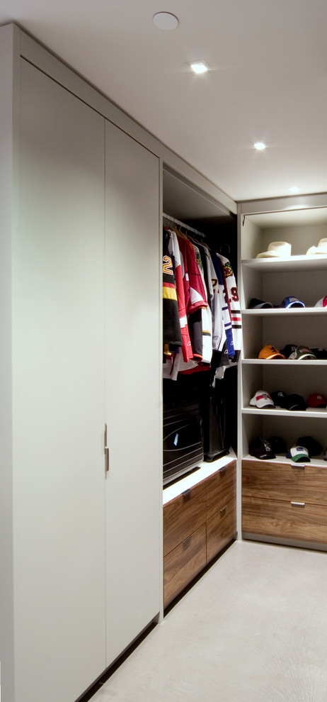 Large modern gender-neutral walk-in wardrobe in Vancouver with flat-panel cabinets, medium wood cabinets and concrete floors.