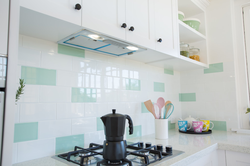Inspiration for a mid-sized traditional u-shaped separate kitchen in Brisbane with a double-bowl sink, shaker cabinets, white cabinets, quartz benchtops, green splashback, subway tile splashback, white appliances, dark hardwood floors, no island, red floor and white benchtop.