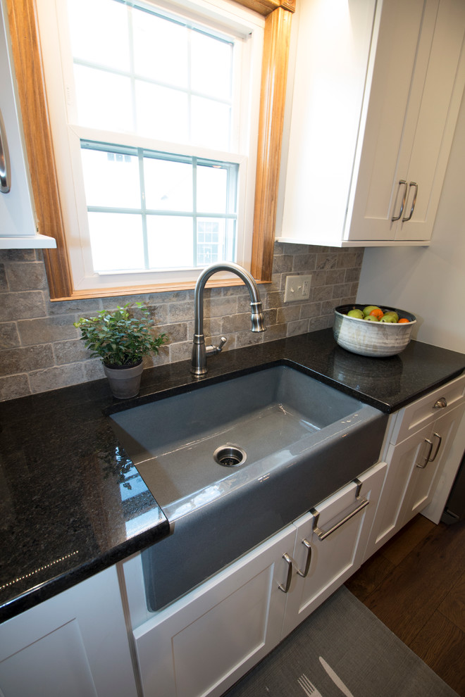 Eat-in kitchen - large transitional l-shaped medium tone wood floor eat-in kitchen idea with an undermount sink, shaker cabinets, white cabinets, granite countertops, gray backsplash, stone tile backsplash, stainless steel appliances and an island