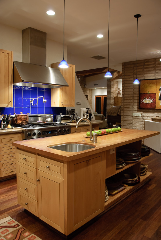 Contemporary galley separate kitchen in Phoenix with an undermount sink, open cabinets, light wood cabinets, wood benchtops, blue splashback, stainless steel appliances and dark hardwood floors.
