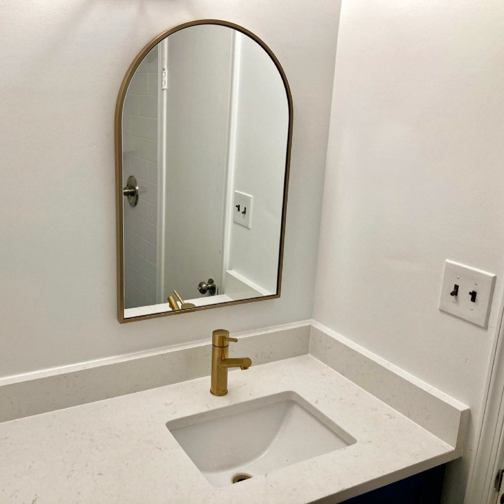 This is an example of a small modern 3/4 bathroom in DC Metro with shaker cabinets, blue cabinets, an alcove shower, a two-piece toilet, white tile, porcelain tile, white walls, porcelain floors, an undermount sink, quartzite benchtops, white floor, a shower curtain, white benchtops, a single vanity and a built-in vanity.