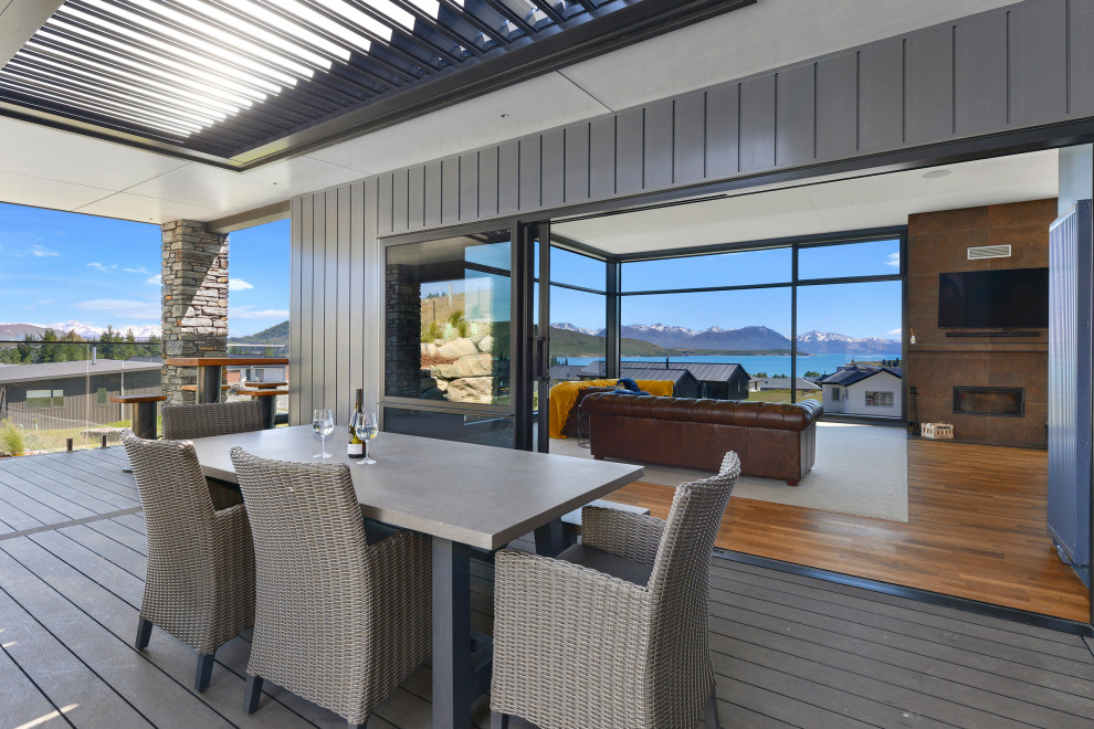 Diseño de terraza contemporánea grande en patio lateral con toldo y barandilla de metal