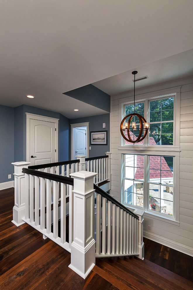 Design ideas for a mid-sized country wood u-shaped staircase in Other with painted wood risers and wood railing.