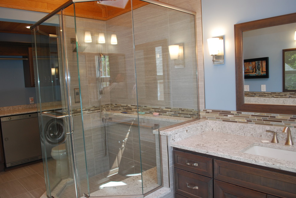 Large contemporary master bathroom in Cleveland with recessed-panel cabinets, dark wood cabinets, a corner shower, a one-piece toilet, gray tile, porcelain tile, blue walls, porcelain floors, an undermount sink, grey floor and a hinged shower door.