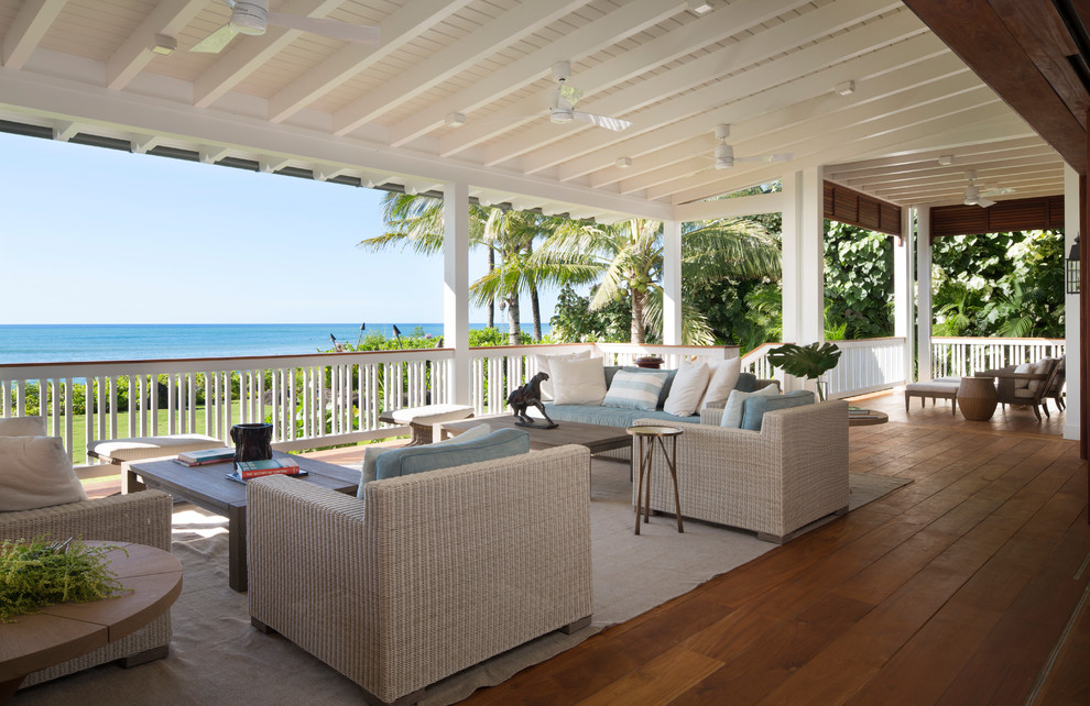 This is an example of a large tropical backyard patio in Hawaii with decking and a roof extension.