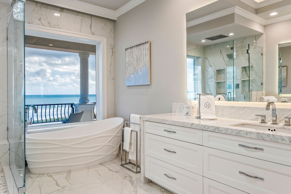Пример оригинального дизайна: большая главная ванная комната в современном стиле с фасадами с утопленной филенкой, белыми фасадами, отдельно стоящей ванной, открытым душем, белой плиткой, керамогранитной плиткой, белыми стенами, полом из керамогранита, врезной раковиной, мраморной столешницей, белым полом, душем с распашными дверями, серой столешницей, нишей, тумбой под две раковины, встроенной тумбой и кессонным потолком