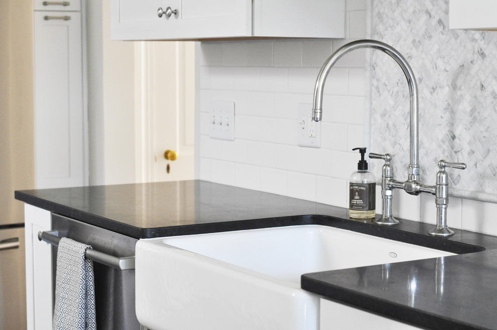 Example of a mid-sized transitional l-shaped medium tone wood floor eat-in kitchen design in Richmond with a farmhouse sink, shaker cabinets, white cabinets, granite countertops, white backsplash, subway tile backsplash and stainless steel appliances