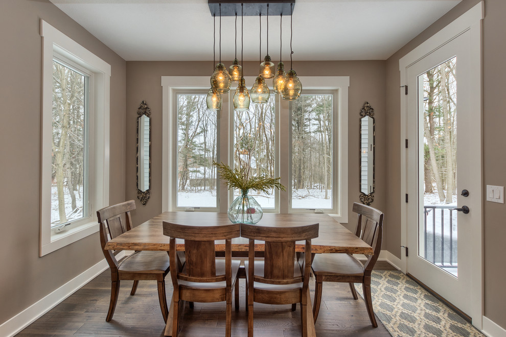This is an example of a country separate dining room in Grand Rapids with grey walls and dark hardwood floors.