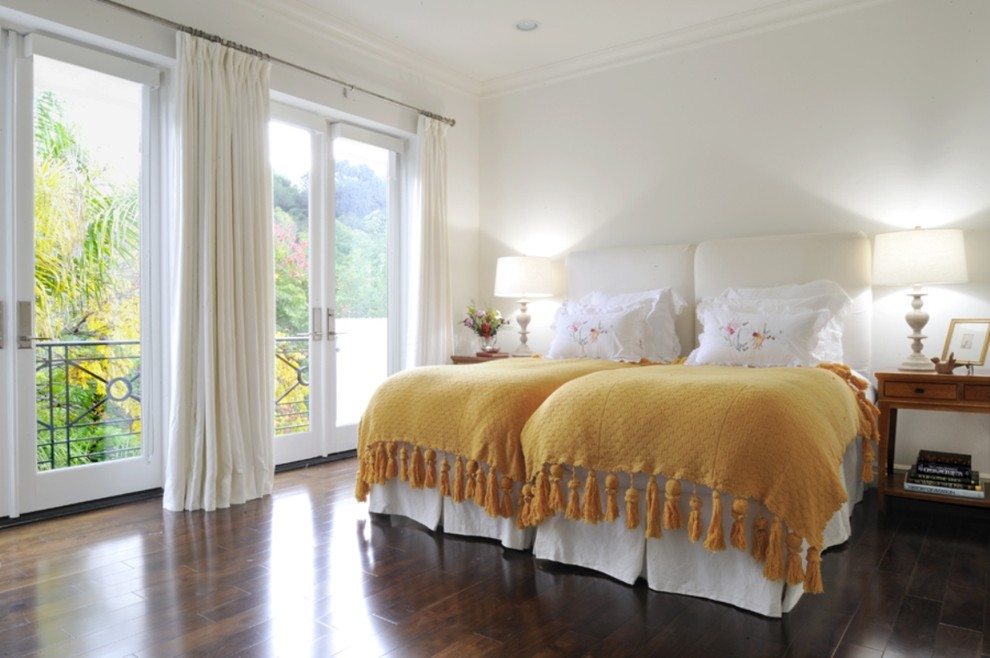 This is an example of a traditional guest bedroom in Los Angeles with white walls and dark hardwood floors.