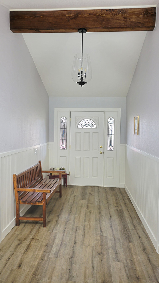 Aménagement d'un hall d'entrée campagne de taille moyenne avec un mur gris, un sol en vinyl, une porte simple, une porte blanche, un sol beige, un plafond voûté et du lambris.