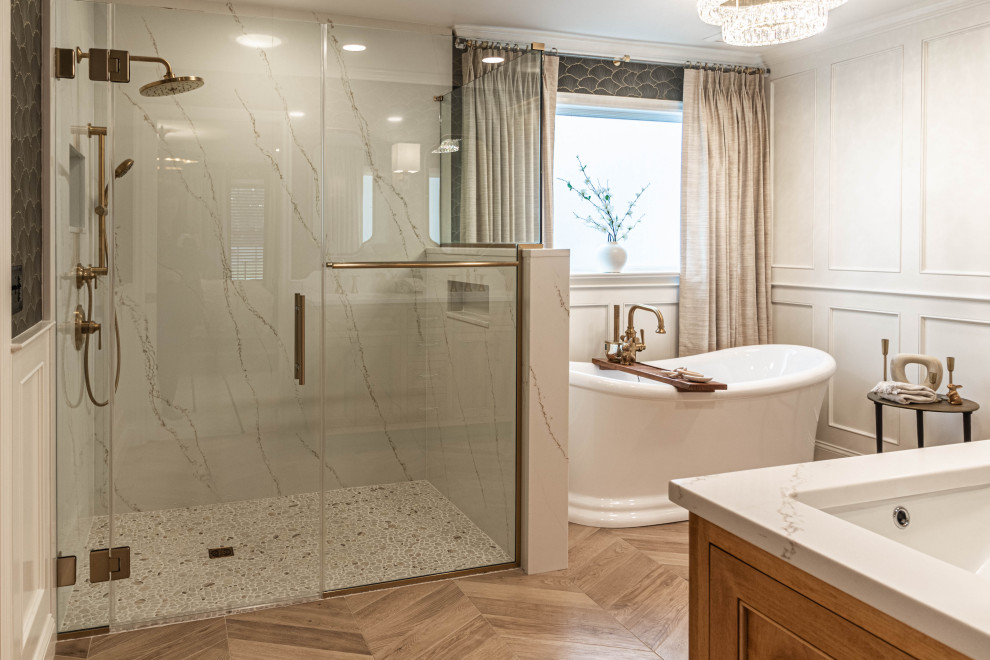 Large transitional master white tile and stone slab porcelain tile, beige floor, double-sink and wall paneling freestanding bathtub photo with beaded inset cabinets, light wood cabinets, a two-piece toilet, gray walls, an undermount sink, quartz countertops, a hinged shower door, white countertops, a niche and a built-in vanity
