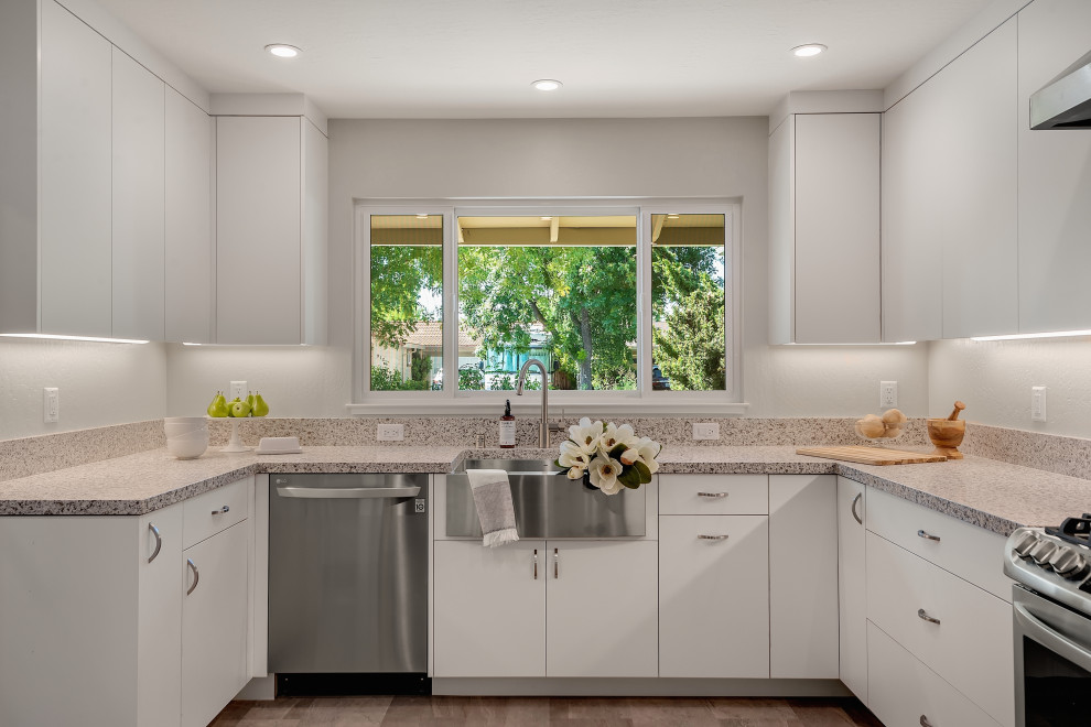Inspiration for a mid-sized modern u-shaped separate kitchen in San Francisco with a farmhouse sink, flat-panel cabinets, white cabinets, quartzite benchtops, grey splashback, a peninsula, grey floor, grey benchtop, wood, stone slab splashback, stainless steel appliances and vinyl floors.