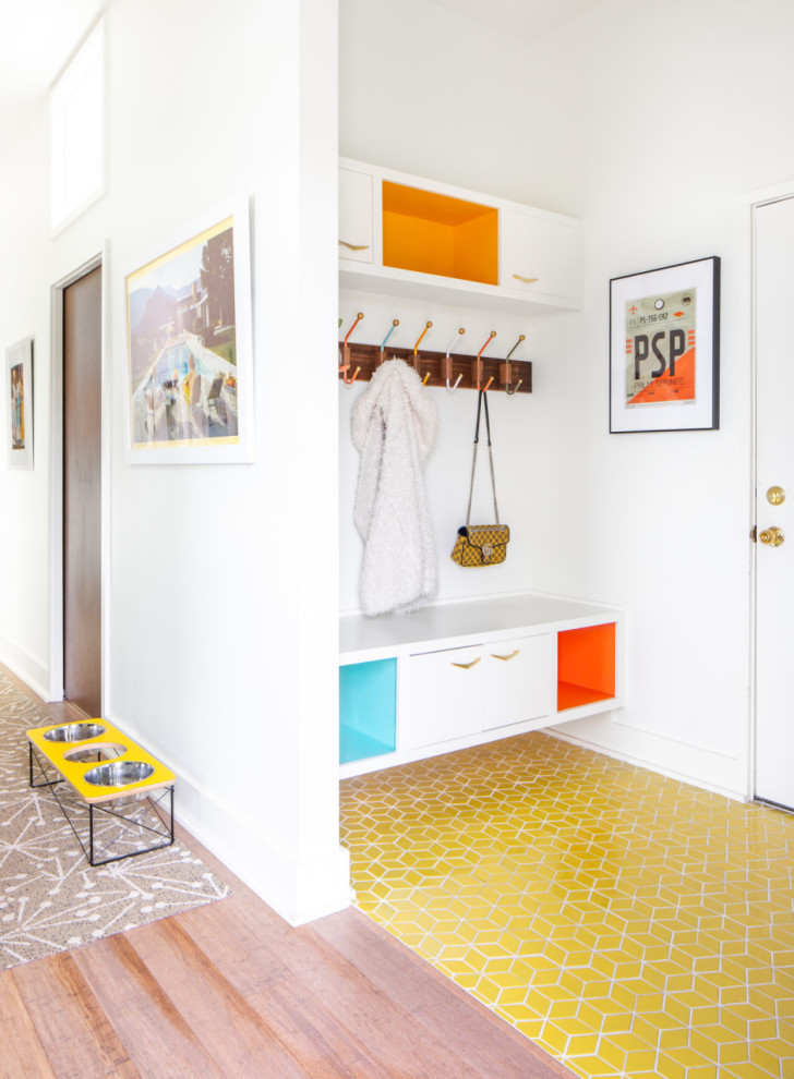 デトロイトにある高級な小さなミッドセンチュリースタイルのおしゃれなマッドルーム (白い壁、セラミックタイルの床、濃色木目調のドア、黄色い床) の写真
