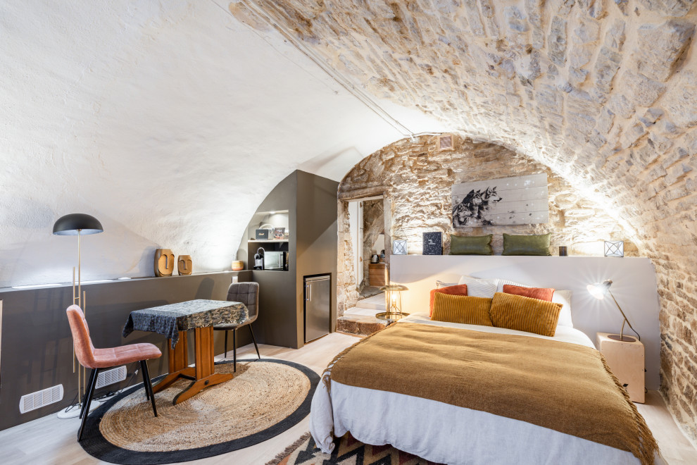 Mittelgroßes Eklektisches Hauptschlafzimmer mit hellem Holzboden, Kamin, Kaminumrandung aus Metall und gewölbter Decke in Montpellier