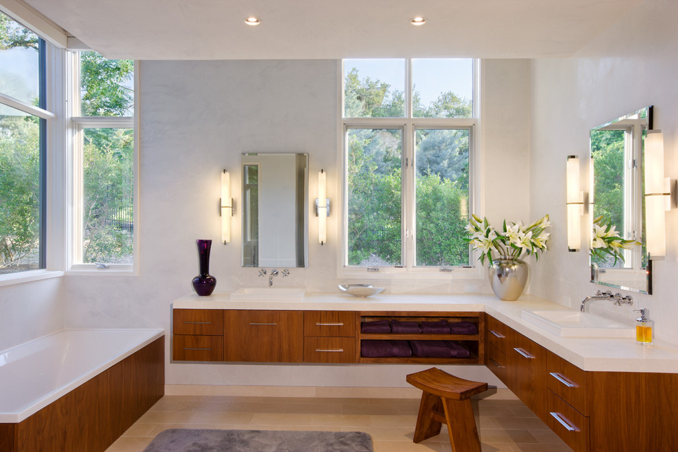 Photo of a contemporary master bathroom in Austin with a drop-in sink, medium wood cabinets, white walls and a drop-in tub.