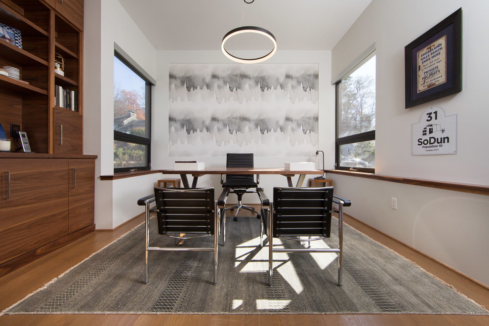 Photo of a mid-sized contemporary study room in Chicago with white walls, medium hardwood floors, a freestanding desk and brown floor.