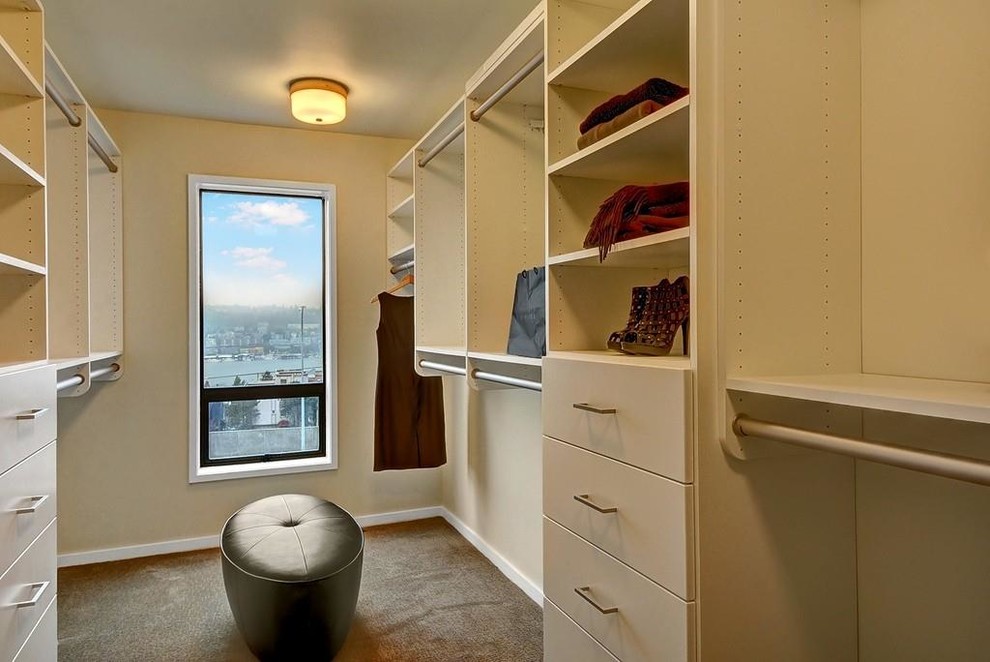 Inspiration for a mid-sized traditional women's walk-in wardrobe in Seattle with flat-panel cabinets, white cabinets and carpet.