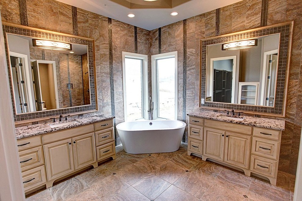 Example of a mid-sized transitional kids' beige tile and stone tile travertine floor and beige floor freestanding bathtub design with raised-panel cabinets, white cabinets, beige walls, an undermount sink and granite countertops
