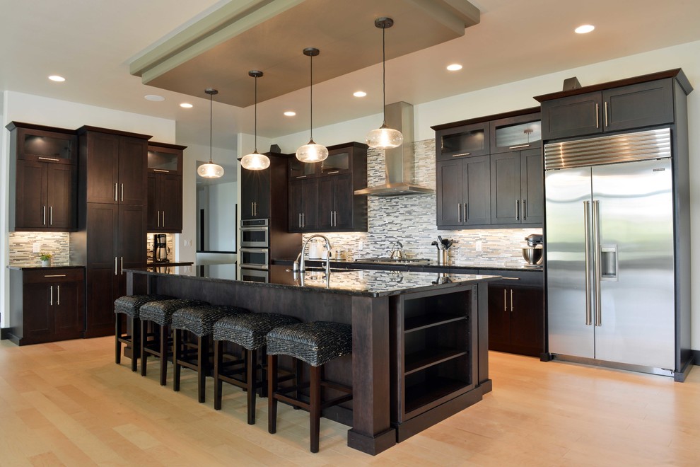Example of a large transitional l-shaped light wood floor and beige floor open concept kitchen design with an undermount sink, shaker cabinets, dark wood cabinets, quartz countertops, multicolored backsplash, glass sheet backsplash, stainless steel appliances and an island