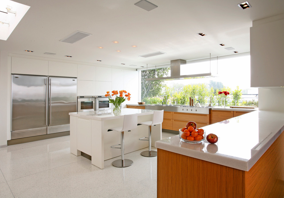 This is an example of a contemporary u-shaped kitchen in Los Angeles with flat-panel cabinets, medium wood cabinets and stainless steel appliances.