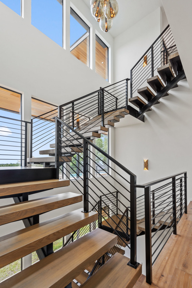 Idées déco pour un escalier contemporain en U de taille moyenne avec des contremarches en métal et un garde-corps en bois.