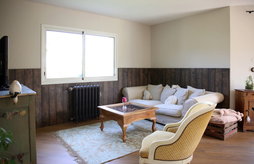 Mittelgroßes, Offenes Retro Wohnzimmer ohne Kamin mit beiger Wandfarbe, Vinylboden, TV-Wand, braunem Boden und Wandpaneelen in Rennes