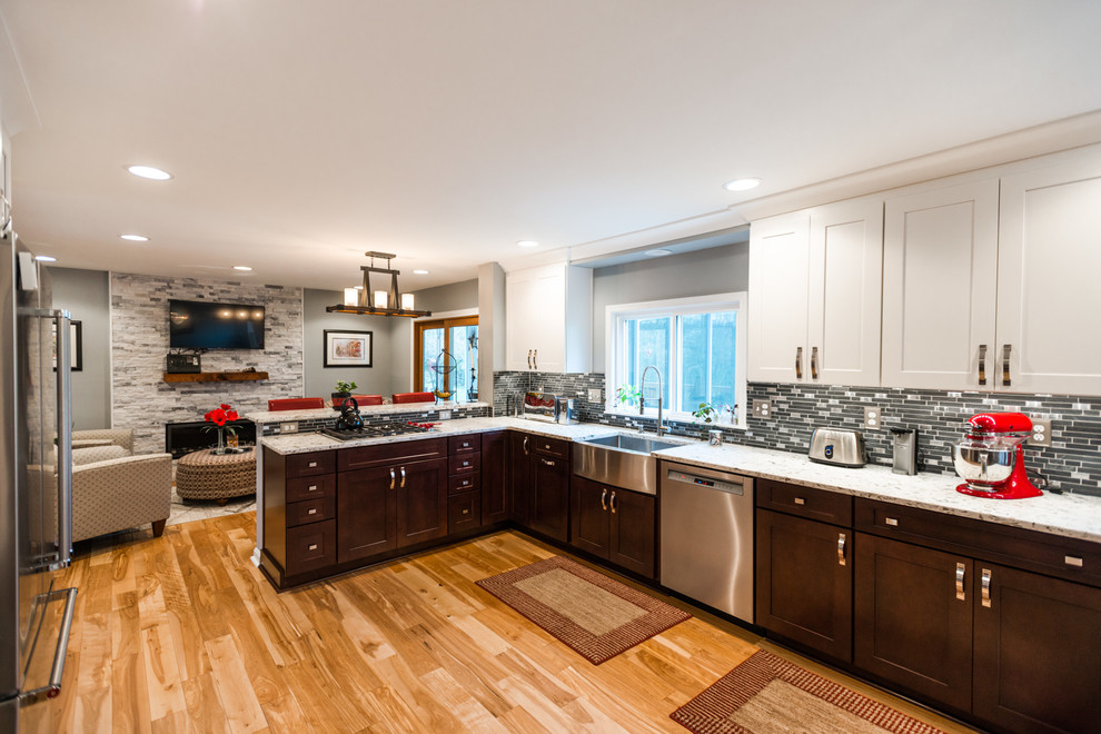 Transitional l-shaped eat-in kitchen in Baltimore with a farmhouse sink, white cabinets, quartz benchtops, grey splashback, mosaic tile splashback, stainless steel appliances, medium hardwood floors and brown floor.