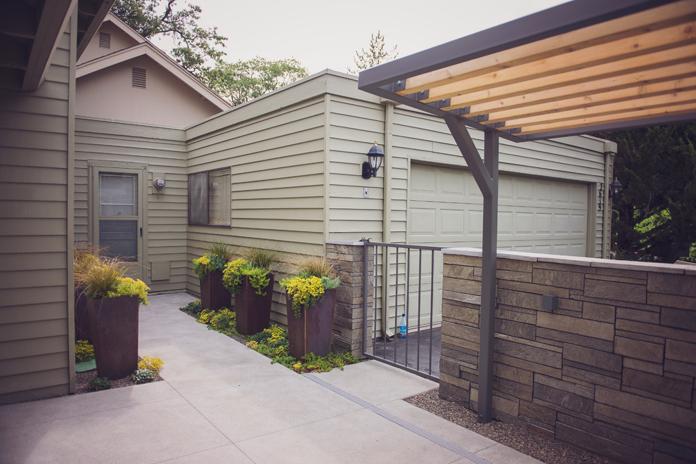 This is an example of a small modern courtyard patio in Other with a container garden, gravel and a pergola.