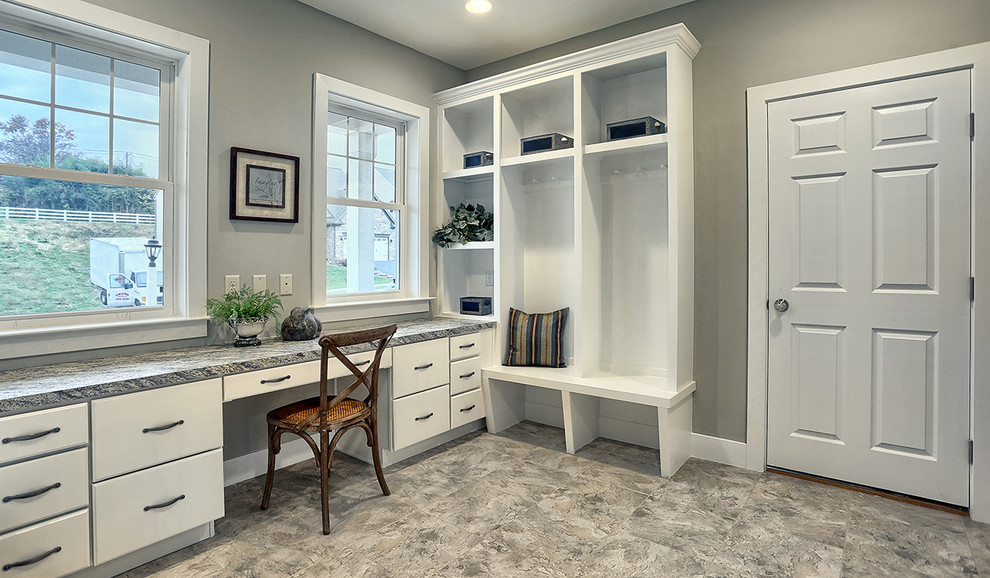 This is an example of a large transitional home office in Other with beige walls, ceramic floors and a built-in desk.